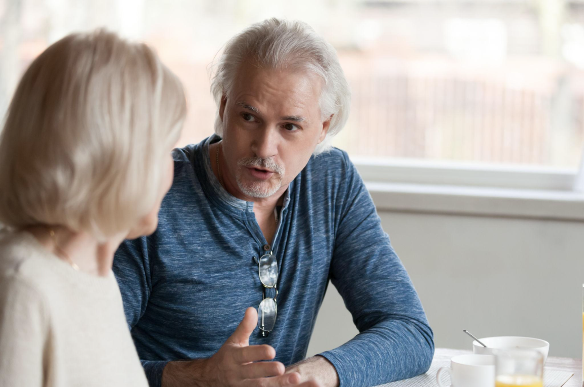 Elegant mature couple having coffee and conversation
